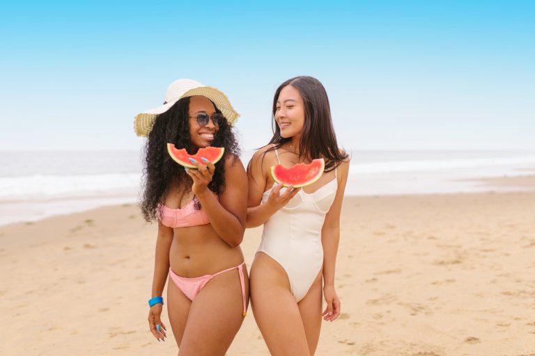 Two women smiling at a beach